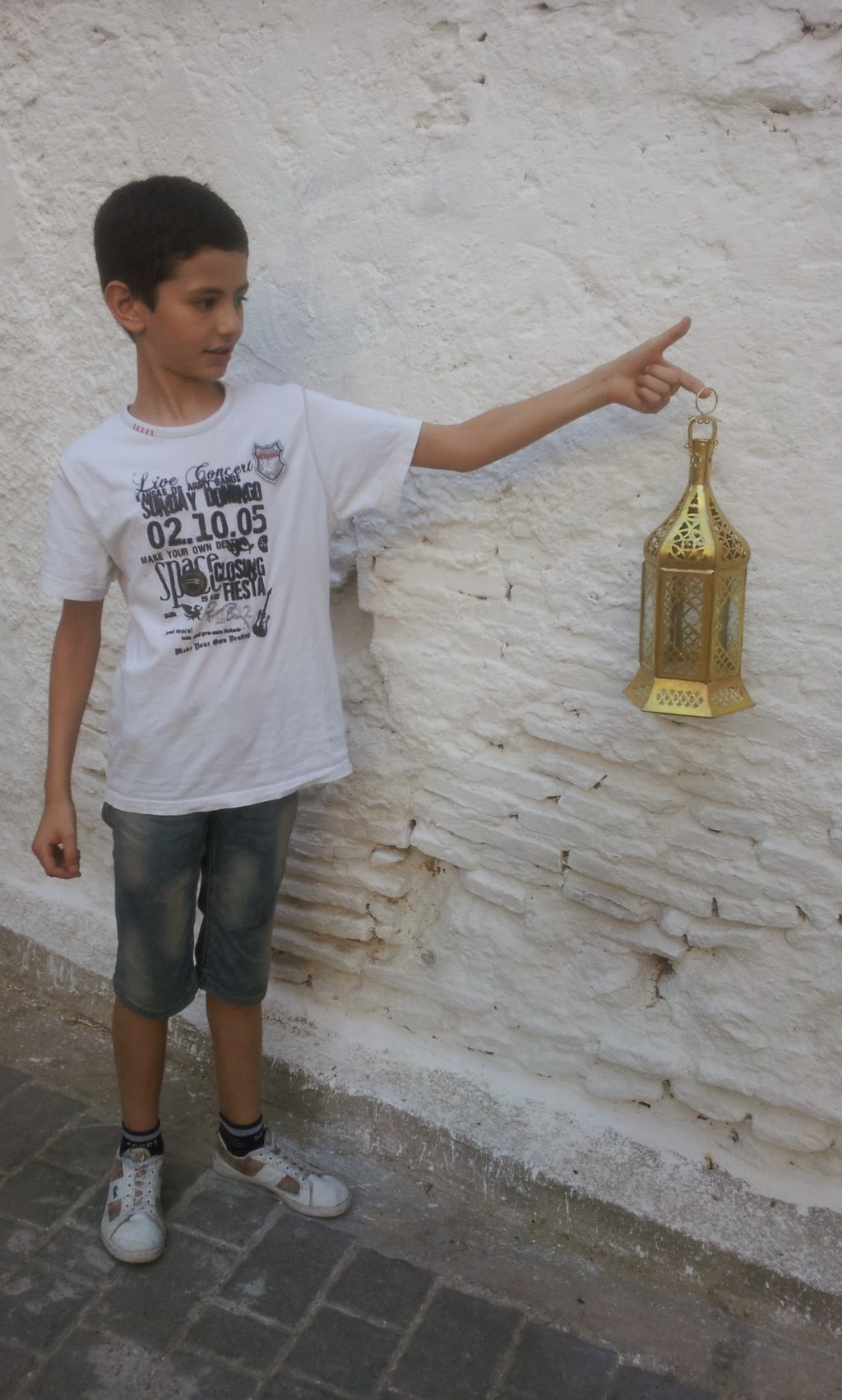 Mohsinne's son holds up a lantern recently made by his father.
