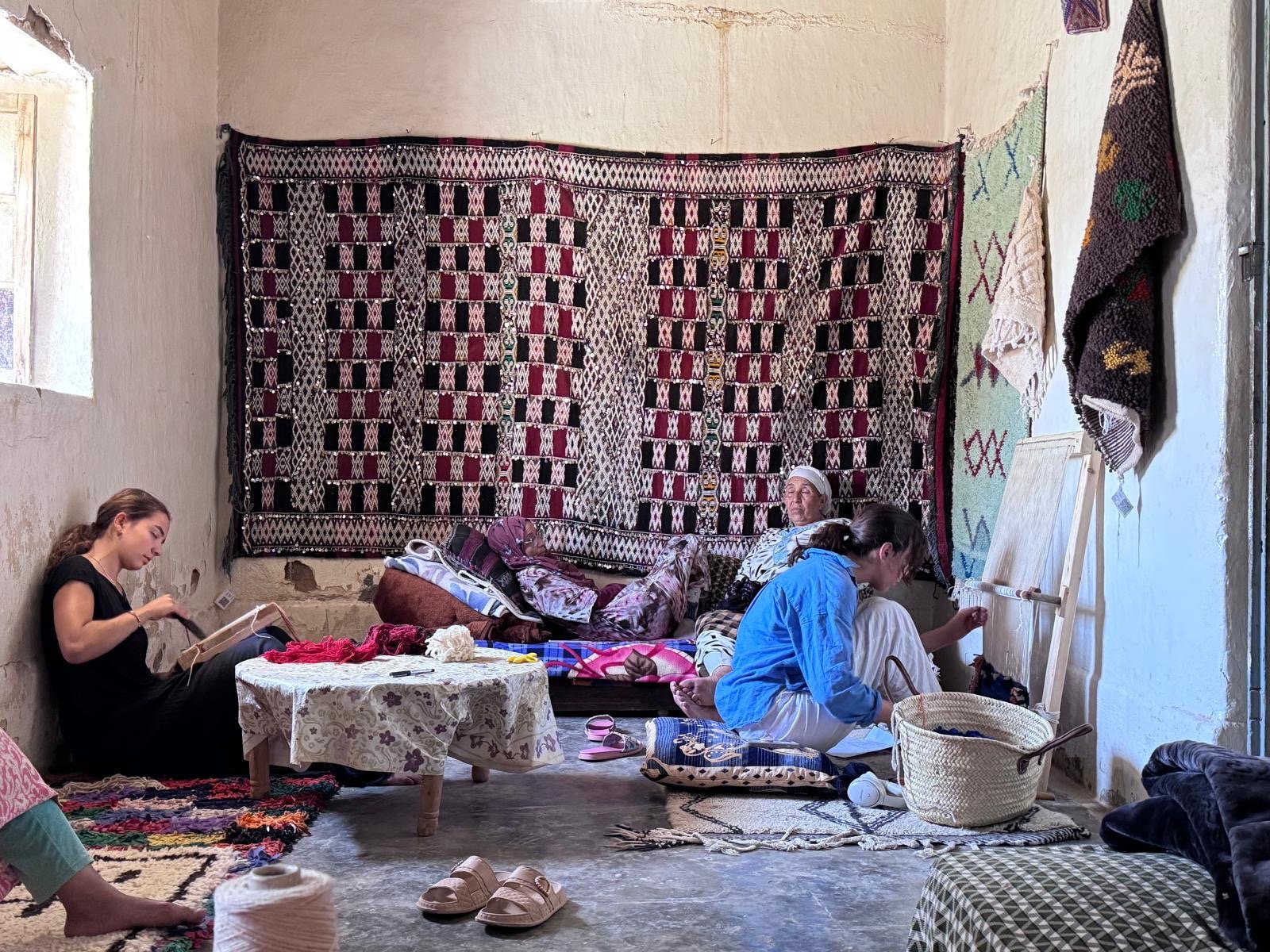Two Fes residents weaving alongside the women of Association Tithrite during a trial residency