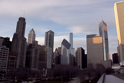 Forty years ago the Prudential building was the tallest in the city of Chicago. Now it disappears into a skyline dominated by sleek skyscrapers. But the solid structure still stands watch over Millennium Park. Its plain façade catches the last rays as the sun sinks behind the rest of the city to the west.