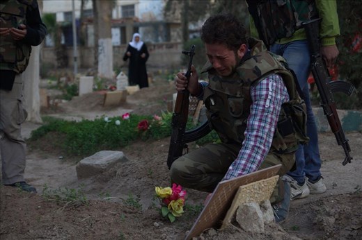 A Free Syrian Army fighter mourns at the grave of his father