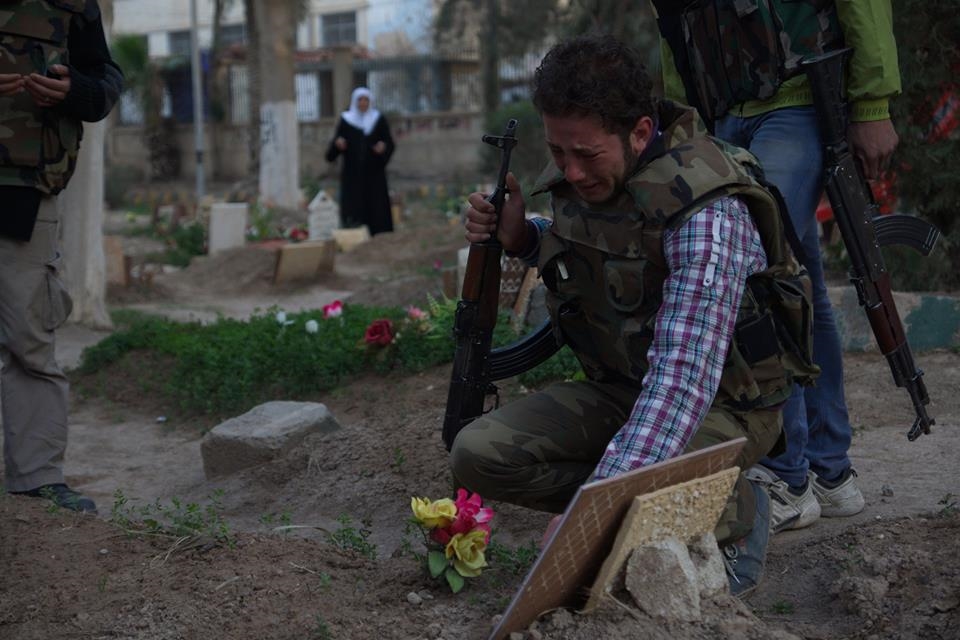 A Free Syrian Army fighter mourns at the grave of his father