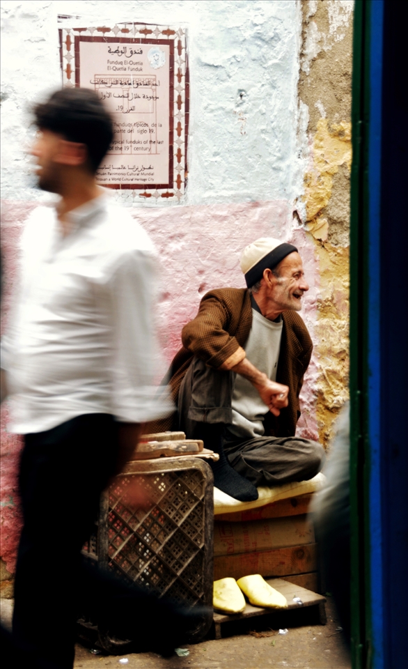 Waiting in the Medina: an old siiting man smiles in a street of Tetouan