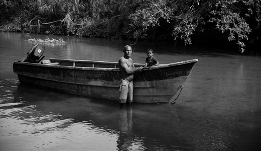 Father and son return up river from the sea after fishing and selling their catch on the shore. Many children will work along side their parents in northern Colombia either along side or instead of formal education