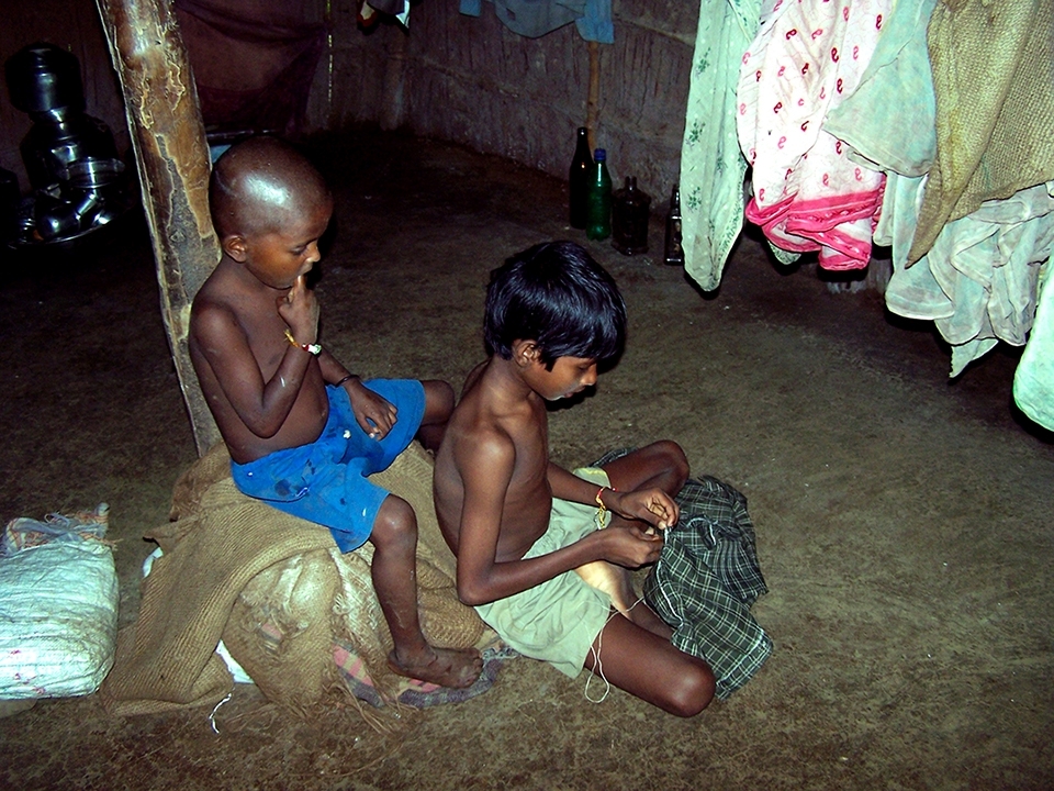This kid was waiting for his elder brother to mend his shirt. He wanted to go out and play in the rain in the company of strangers from the city.