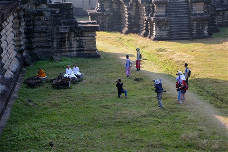 Buddhist monks meditating at Angkor Wat caught attention of tourist photographers