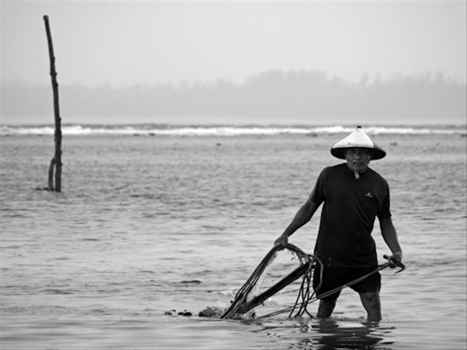 Fisherman out in the sea, while the rain is falling, but he has no choice.