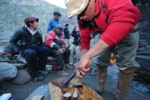 Arrieros feast on a meal of steaks and grilled meat