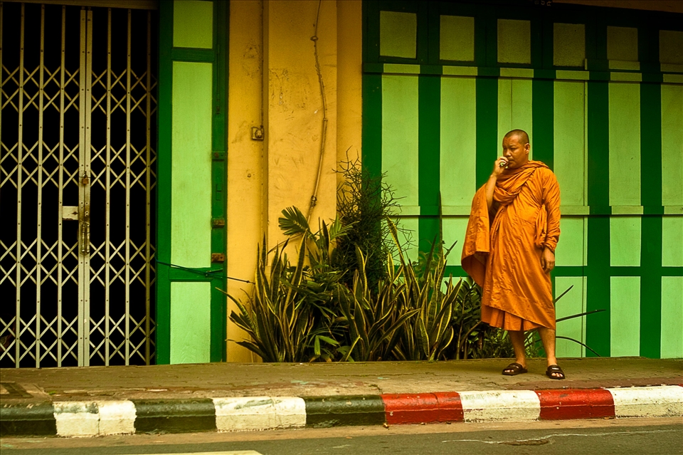A Buddhist Monk having a smoke break from attempting to attain enlightenment.  Buddhism is the main religion in Thailand, in fact 90% of the 8 million citizens living in Bangkok are Buddhists.