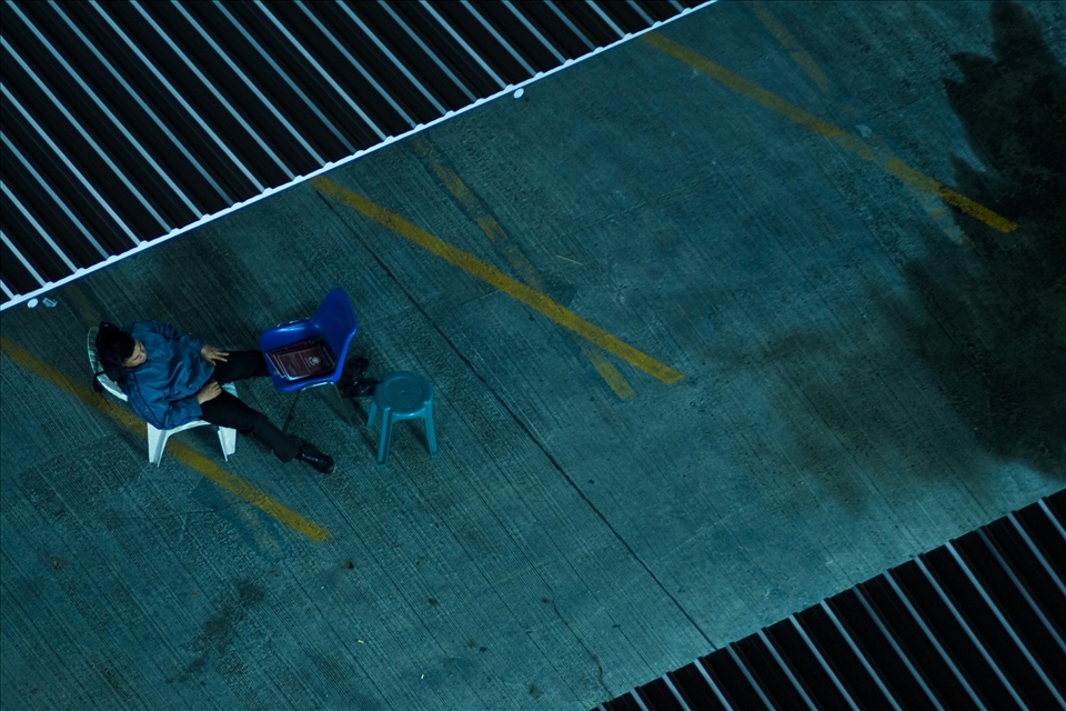 Bangkok is truly a city that never sleeps, even late at night the streets are bustling, this car park attendant has found a moment of piece during his night shift.