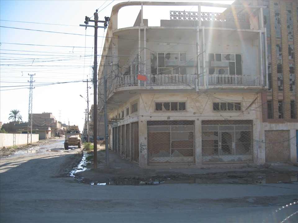 One of our MRAP's next to a bullet riddled building in Samarra, Iraq.