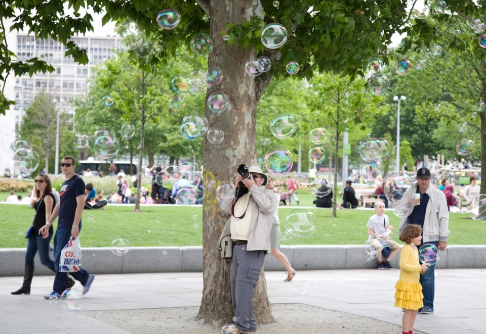 Photographer at the South Bank trying to capture some memories with the bubbles.