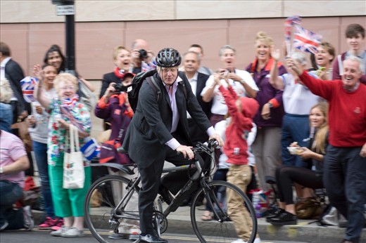 The Mayor of London rode through the middle of the road. People cheered for the man and achievement he has accomplished.