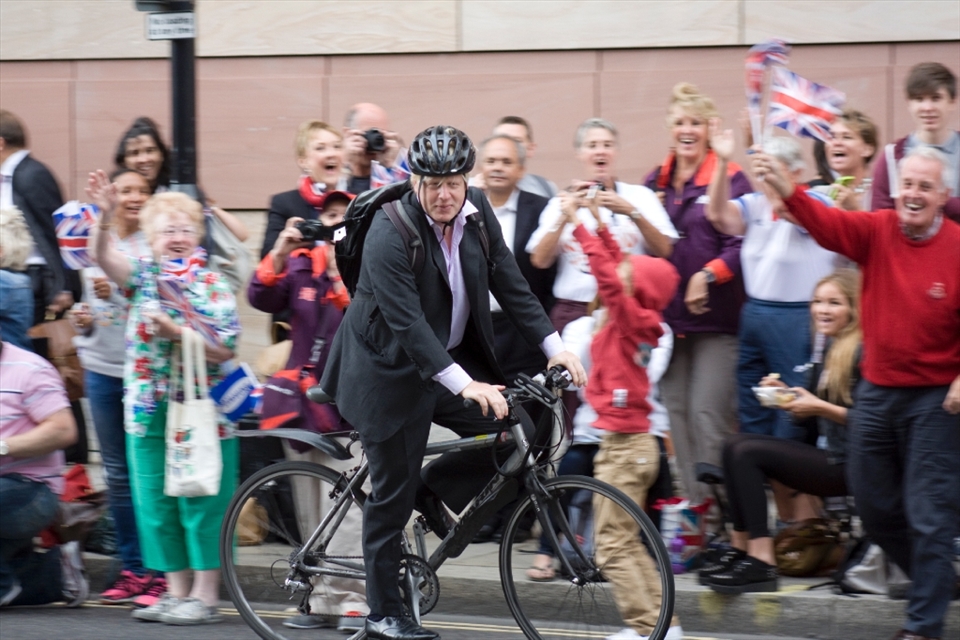The Mayor of London rode through the middle of the road. People cheered for the man and achievement he has accomplished.