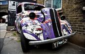 Old abandoned car that was originally placed here as an art piece but gradually over time people have sprayed graffiti and advertising stickers on it.: by adampassingham, Views[421]