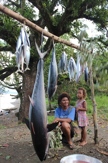 Mother and daughter selling freshly caught juvenile and mature tuna on the road 