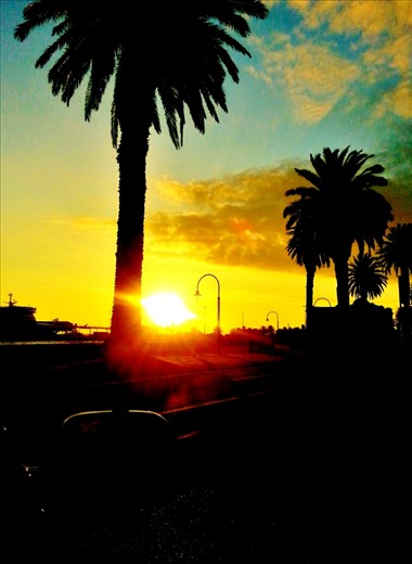 Sun Set at St.Kilda Beach in Melbourne. actually i was trying to focus the sun from the back seat of my car behind the driver but when i saw the picture after capturing i thought its more artistic to leave it as it is. may be by professional's point of view its some thing ordinary or not but to me it looked amazing. the combination of sky colours and black looks awesome.