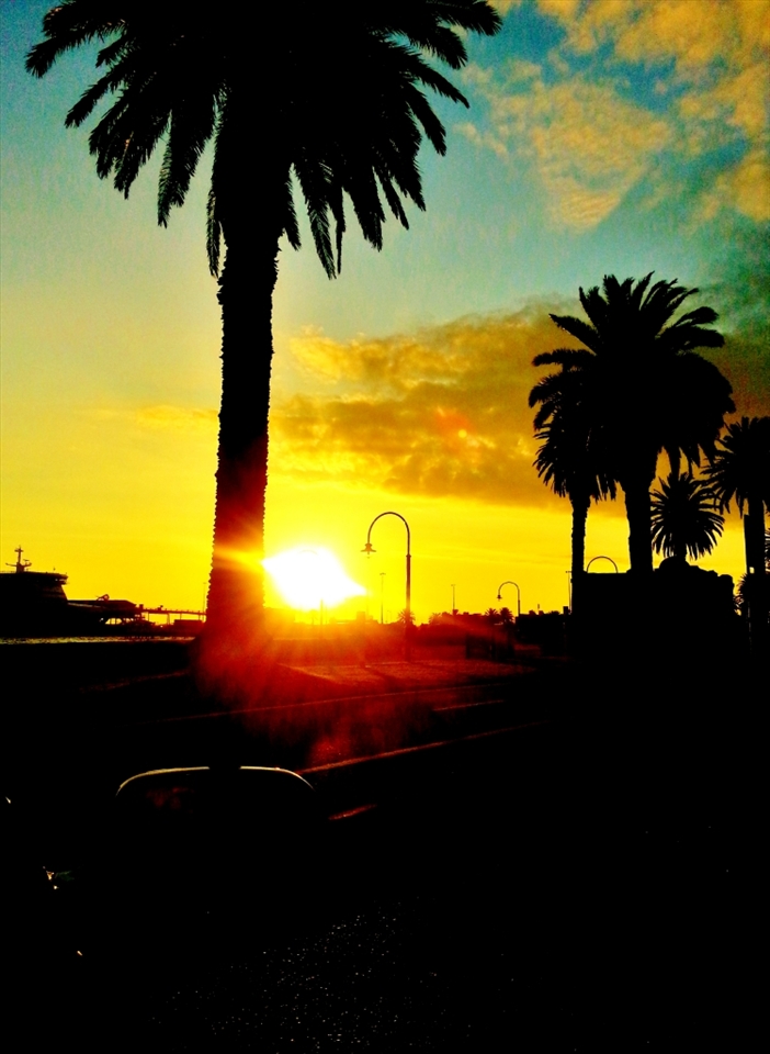 Sun Set at St.Kilda Beach in Melbourne. actually i was trying to focus the sun from the back seat of my car behind the driver but when i saw the picture after capturing i thought its more artistic to leave it as it is. may be by professional's point of view its some thing ordinary or not but to me it looked amazing. the combination of sky colours and black looks awesome.