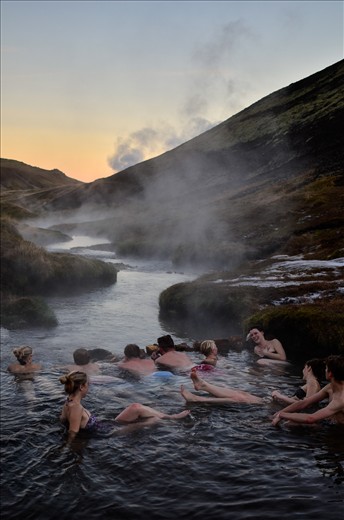 Hikers take a break to bathe in a natural hot river near Hveragerði, Iceland.