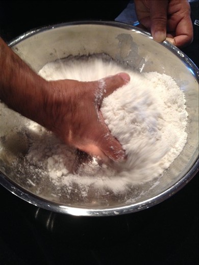 Mixing puttu: rice flour, salt, coconut flakes and water with hand
