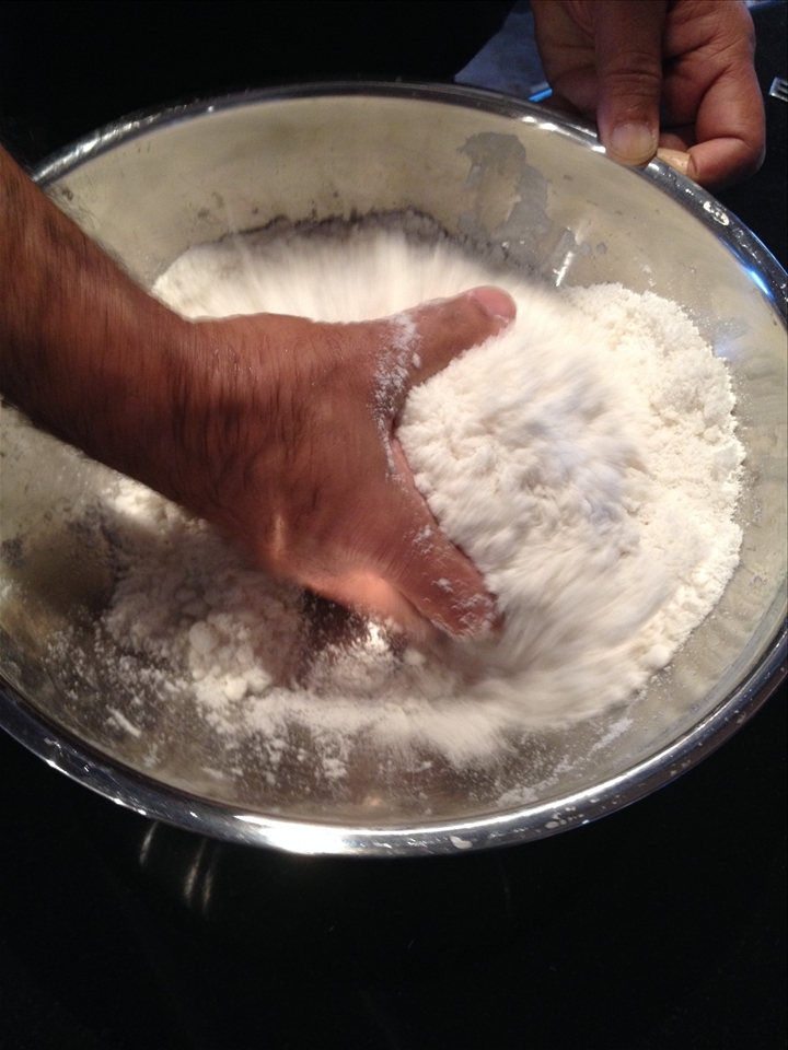 Mixing puttu: rice flour, salt, coconut flakes and water with hand