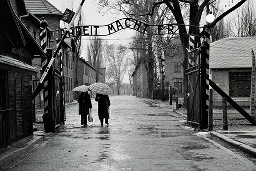 ‘Labor Makes you Free’. Two women pass through the entrance to Auschwitz I – a concentration camp from World War II located in Poland. The site has since been converted into a museum which tells the story of the horrors faced by those taken there. 