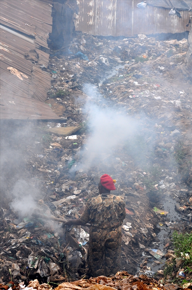 The woman tires to 'recycle' the dump by burning it but this pollutes the air.
