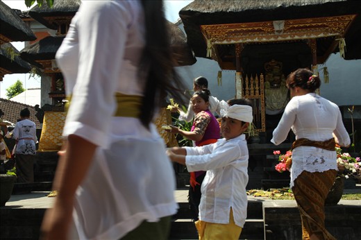 Numerous festivities are held throughout the year involving family members of all ages. This shot conveys the hastiness in one of the temples in Kuta on Galungan. Gifts are being laid in traditional fancy costumes wore on that occasion. 