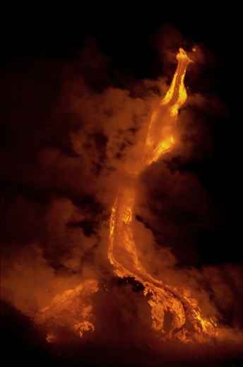 The lava is flowing down from what looks to be a dragon's mouth. Steam rises from the molten lava as it hits the oncoming waves. Moments later, a large piece brakes off and changes the path of the flowing lava. 