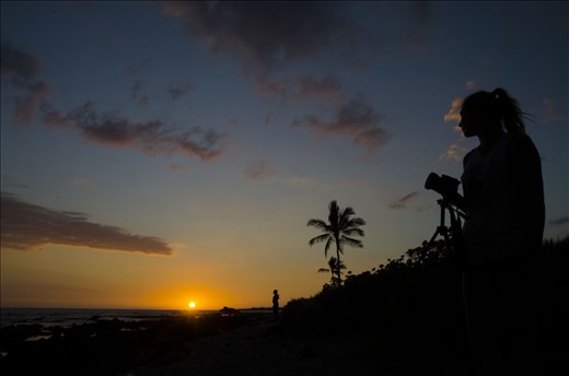 As another day comes to an end in Kona Town locals stop to watch the colors play upon the sky as the sun sets into the ocean.