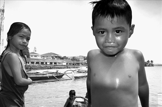 On the right side of our port is a group of children enjoying the shore. 