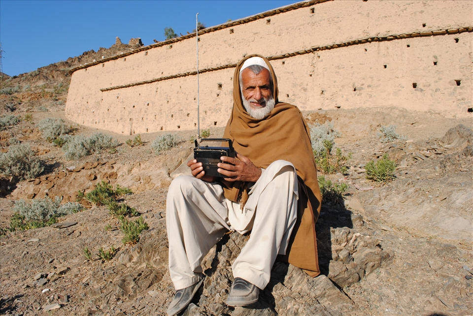 an old man having Radio which is a good mean of communication in tribal area