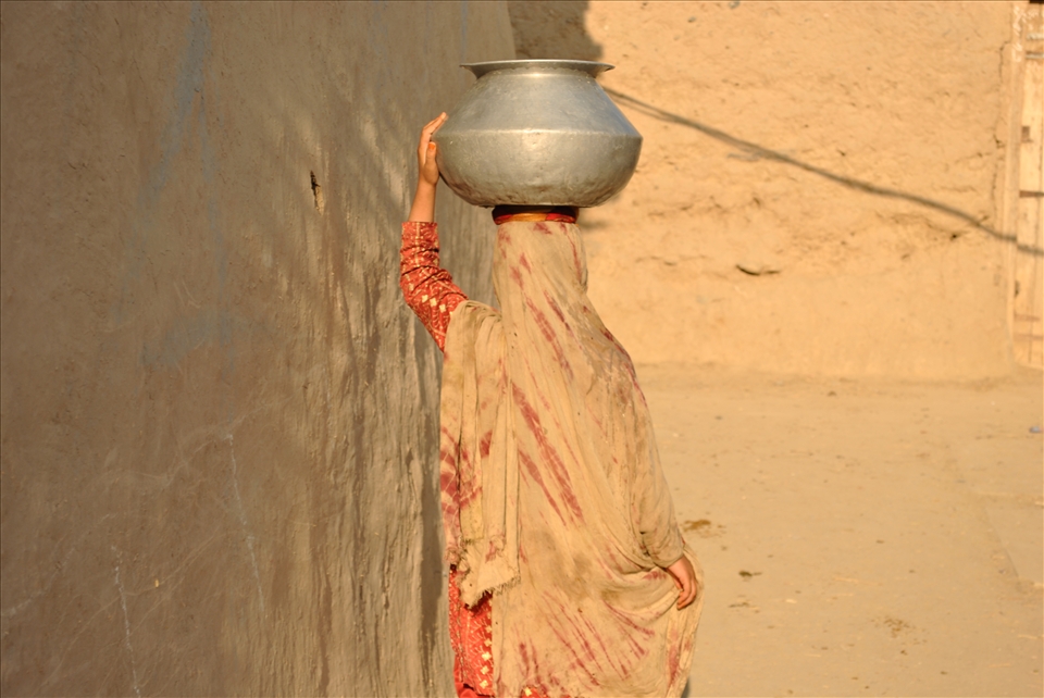 A women returns home after fetching water in a village in(FATA) for Domastic use