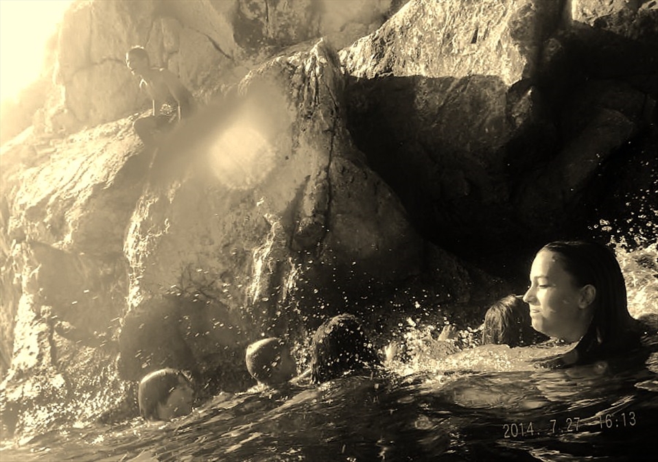 [It's a hot summer's day and all I hear are screams.] Children are swimming farther out into the ocean than I ever dared to when I was their age. One has clambered up the rocks, soft skin on jagged earth's head, and braces himself for the leap into pure blue. Pain in the pause between breaths, but that is why they're having so much fun.