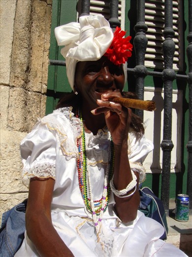 A Cuban woman in traditional Cuban attire posing for tourists with a constant smile on her face. Is this the reality? 
