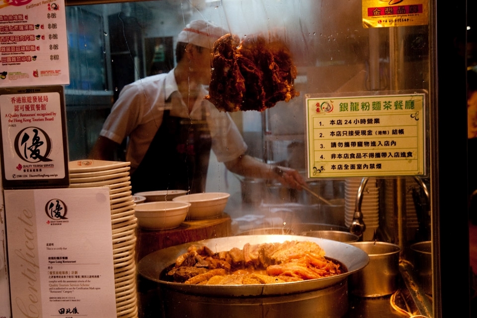 One of the places where you can stop and buy something to eat. It's very common to see the kitchens from the street like that and see the cook doing his work surrounded by vapour and food