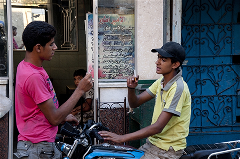 A child watches two teenagers trying to prove their manhood sharing cigarettes