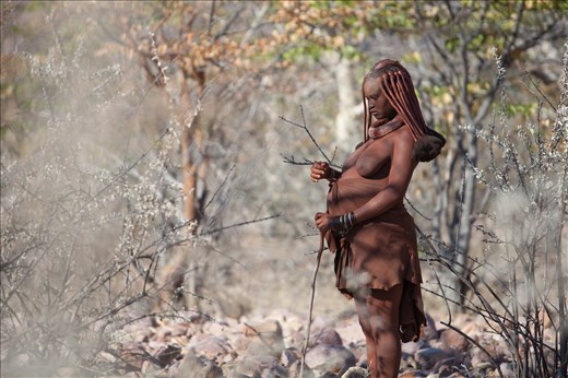 Meet  Menjamwapi, A nine months pregnant Himba Woman. She lives with her mother and two sisters near Epupa falls in the Kaokoland region. This photo of Menjamwapi  herding her goats was taken a day before  she gave birth.