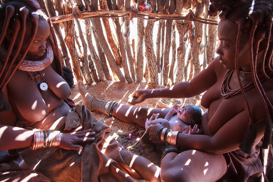 After many hours Menjamwapi has given birth. 
Straight after birth, the baby was rubbed in soil to remove all fluids and the umbilical cord was cut and buried in the soil of the hut to represent the newborns connection to her ancestors land. 