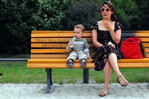 A woman and her son eat ice cream on a park bench in Kreuzberg, Germany.