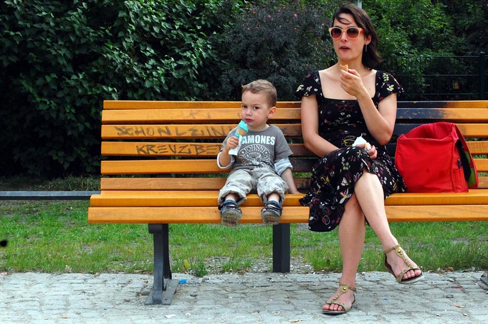 A woman and her son eat ice cream on a park bench in Kreuzberg, Germany.