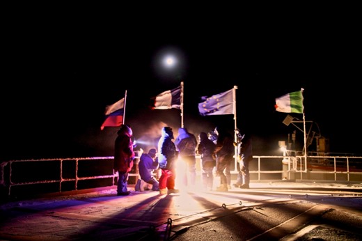 From May to August, the sun will set below the horizon leaving you in 3 months of complete darkness.  Your mind starts to fold inwards as the temperature plummets.  If you are not careful in the perpetual darkness your hormone regulated sleep cycle will spiral out of control and you will 'freewheel' around the world's timezones, waking up in Fiji and going to bed in Bulgaria.  

The loss in circadian rhythm is an important element to study in relation to understanding the effects of long distance class space missions on human psychology and physiology, where you would experience the effects of altered day-night cycle, having to endure long periods of darkness.  

This photo was taken at the height of midwinter.  It shows the world's coldest and most remote Diamond Jubilee tea Party.  The entire crew enjoyed freshly brewed tea and baked scones on the rooftop in -75C in the darkness.  The scones soon turned to concrete and the porcelain tea cups froze to our lips.  But it is important to share in any activities which all count towards keeping people's minds and the team entertained and sane during winter.