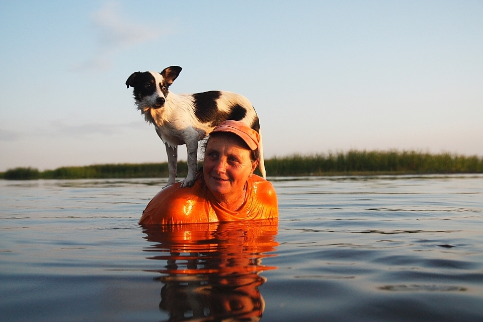 On a torrid day, a woman and her dog cool off  in a small channel near Letea, a village in Danube Delta, Romania.