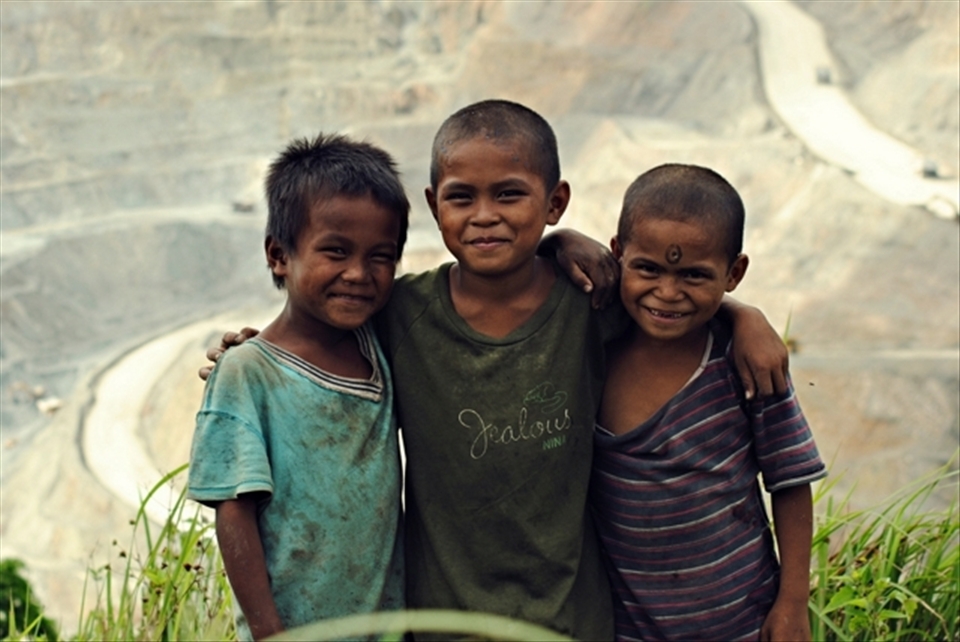 Painted smiles overwhelming the view of natural playground with a backdraft of a copper mine site.