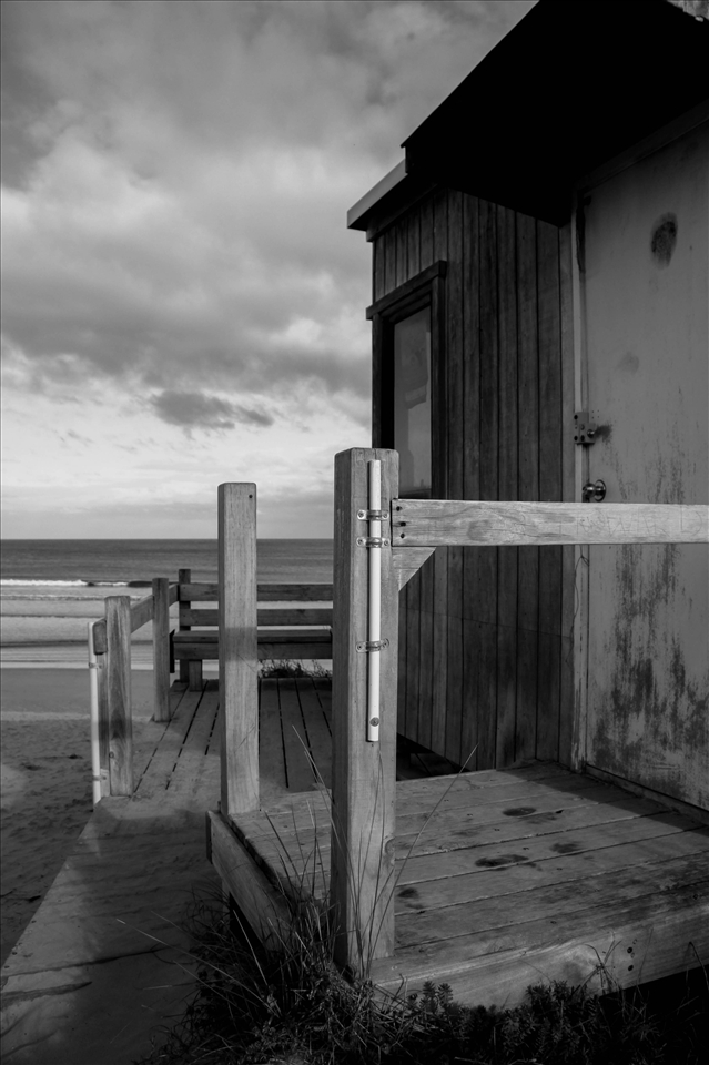 A deteriorating unused lifesaver box sits proud on the top of the dunes