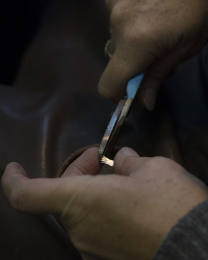 She trims off the excess metal to achieve the shape and size she wants 