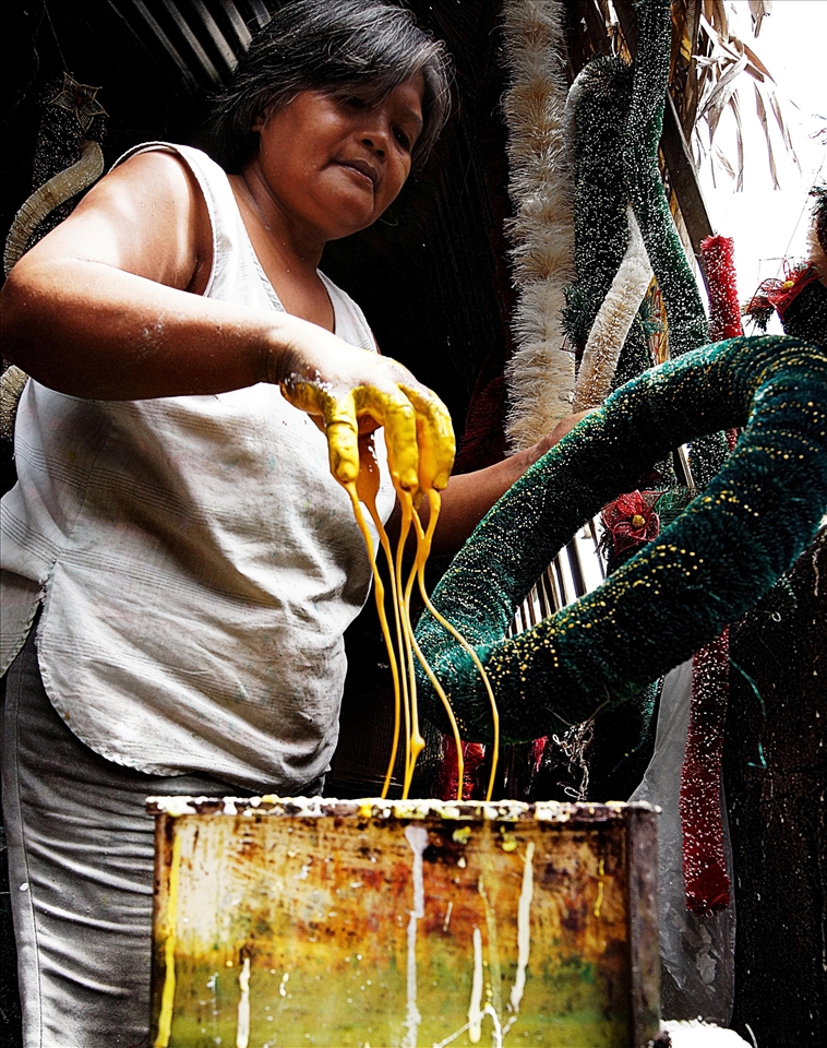 A woman decorating a lantern.