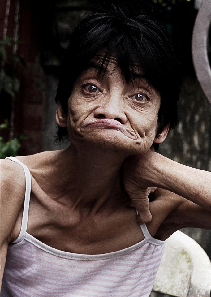 A beautiful lady watching the people go pass by her house.
