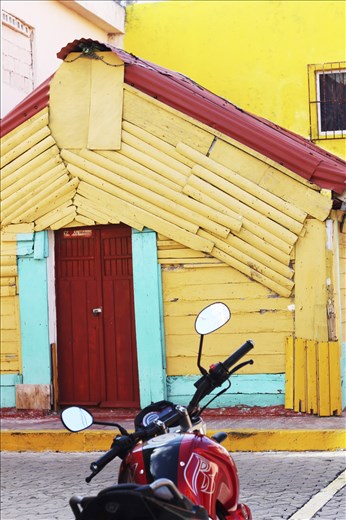 Motor bike parked along brightly colored buildings