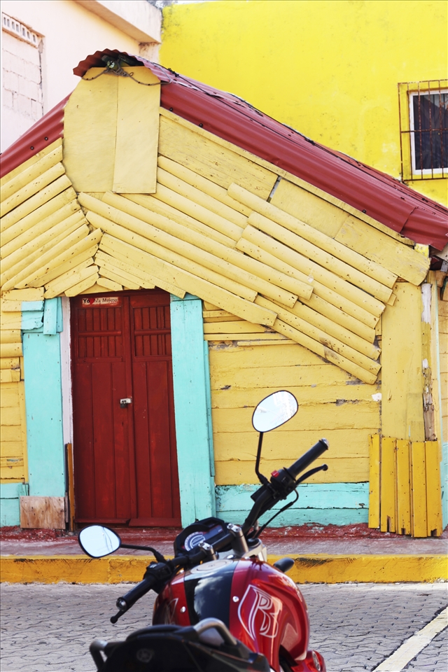 Motor bike parked along brightly colored buildings