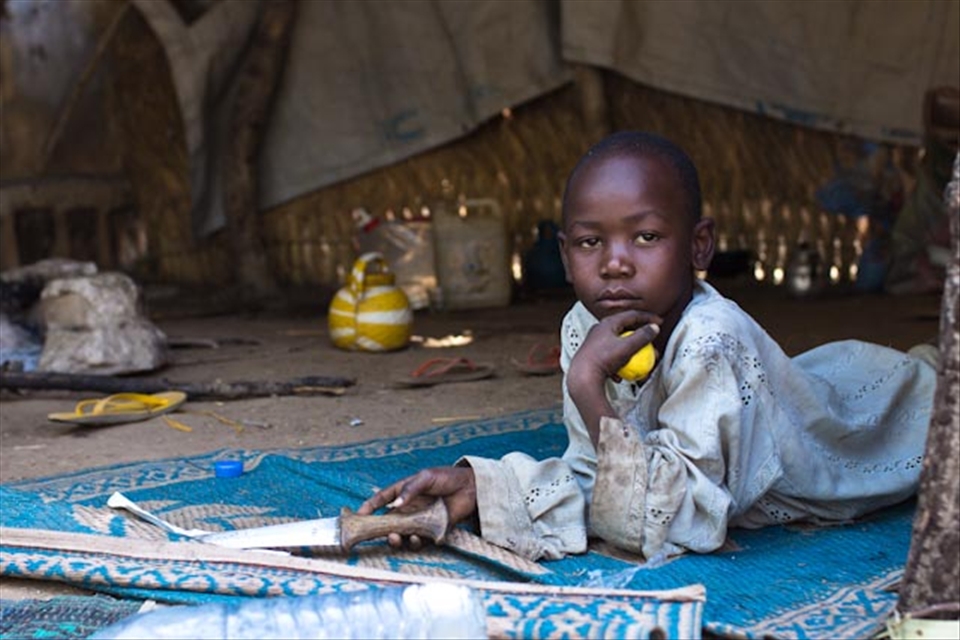 Assan in an improvised camp just outside N'Dele. His family moved here after the town was taken over by rebels. A recurrent event in this part of the world. Not even exciting anymore. Now he is waiting for things to settle down and for his school to open again.